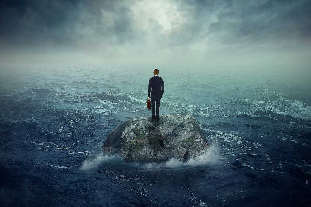 businessman on a rock in a stormy ocean
